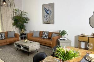 a living room with brown couches and a table at Yas Island Oasis Getaway 1BR Amazon in Abu Dhabi