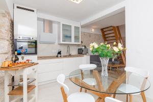 Apartment Meri في سوتيفان: مطبخ وغرفة طعام مع طاولة وكراسي زجاجية