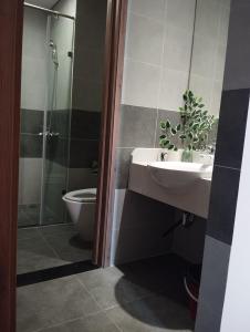 uma casa de banho com um lavatório, um chuveiro e um WC. em Sky Oasis 2 Room 2wc Homestay Ecopark em Hanói