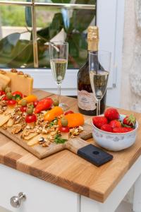 una tabla de cortar con verduras y una botella de vino en Apartment Meri en Sutivan