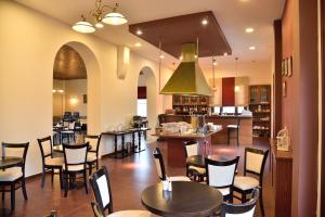 a restaurant with tables and chairs and a kitchen at Byzantion Hotel in Mystras