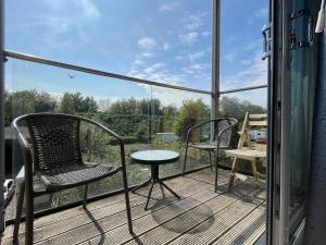 a balcony with two chairs and a table on a deck at Stylish Station Apartment in Rochester with Free Parking in Wainscot