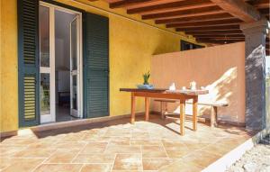 a patio with a wooden table and a bench at 1 Bedroom Pet Friendly Home In Orosei in Orosei