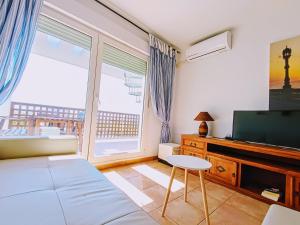 una camera con letto, TV e finestra di Apartamento Levante a Conil de la Frontera
