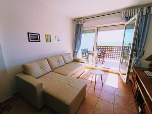 a living room with a couch and a balcony at Apartamento Levante in Conil de la Frontera