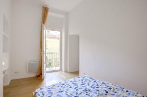 a bedroom with a bed and a door to a balcony at Appart Hotel Jaures - Boutique apartments in Nice