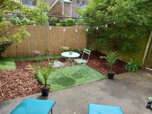 un jardín con mesa, sillas y una valla en La Pléiade Dorée - Extra Centre - Wifi HD - Terrasse & Jardin en Amiens