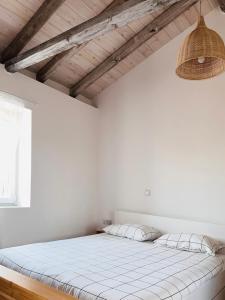 a bedroom with white walls and a large bed at Surf-themed stone house at Kalliopi 2 in Kalliópi