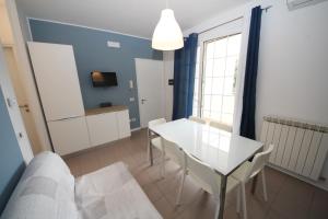 a living room with a white table and chairs at Residence Verdena appartamento 03 in Rosolina Mare