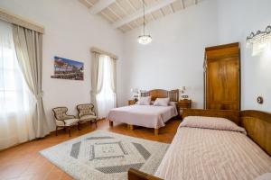 1 dormitorio blanco con 2 camas y sofá en Seranova Luxury Hotel - Adults Only en Ciutadella