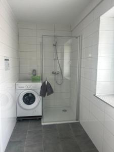 a bathroom with a shower and a washing machine at Montagewohnung/Grünberg in Grünberg