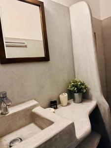 een badkamer met een wastafel en een spiegel bij Nostos Studios in Parikia