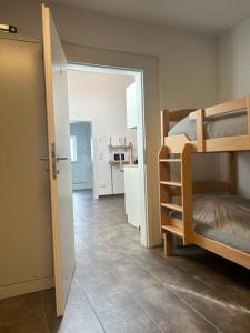 a bedroom with a bunk bed and a hallway with a kitchen at Montagewohnung/Grünberg in Grünberg