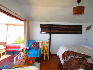 a bedroom with a bed and a blue chair at Titicaca tikary's lodge in Puno