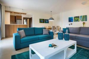 a living room with a blue couch and a table at Eucalyptus suite sea view in Karavomylos