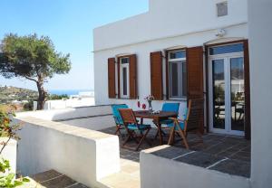 a patio with a table and chairs in front of a house at Villa Depasta Cycladic house Aegean Sea view in Apollonia