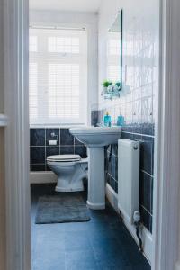 a bathroom with a sink and a toilet and a window at Stunning 4 Bedroom Entire Home in Southampton