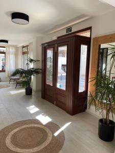 un hall avec une porte en bois et des plantes en pot dans l'établissement Hostal Mallorca, à Sant Antoni de Portmany