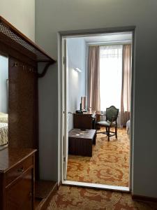 a bedroom with a door open to a room with a desk at Готель Пасаж in Odesa