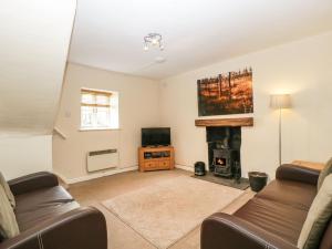 a living room with a couch and a fireplace at Aqueduct Cottage in Abergavenny