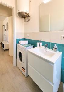 een badkamer met een wasmachine en een wastafel bij Murphy Holiday Homes - Residenza Solari in La Maddalena