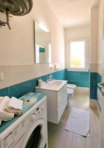 een badkamer met een wasmachine en een wastafel bij Murphy Holiday Homes - Residenza Solari in La Maddalena