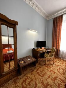 a room with a desk and a bed and a mirror at Готель Пасаж in Odesa