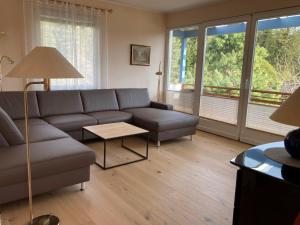 ein Wohnzimmer mit einem Sofa und einem Tisch in der Unterkunft Ferienhaus Karawankenblick Velden in Velden am Wörthersee