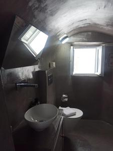 bagno con lavandino, servizi igienici e finestra di AQUA SERENITY LUXURY SUITES SANTORINI a Foinikiá