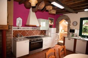 cocina con electrodomésticos blancos y paredes púrpuras en Casa de Piñeiro y SPA (opcional), en Santiago de Compostela