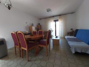 sala de estar con mesa, sillas y sofá en Apartment Laura en Tisno
