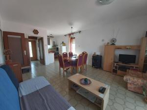 a living room with a couch and a table with chairs at Apartment Laura in Tisno