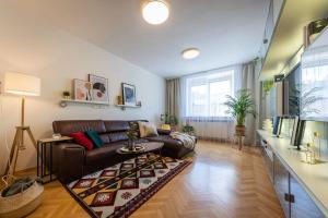 a living room with a leather couch and a rug at I & I Apart, Garage - historical old town Bratislava in Bratislava