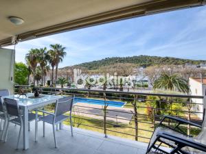 a balcony with a table and chairs and a view of a pool at Gavines del Port in Platja d'Aro