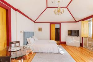 a bedroom with a bed and a table and a tv at Quinta de Castelhão in Barcelos