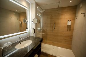 uma casa de banho com um lavatório e um chuveiro em Crowne Plaza Maastricht, an IHG Hotel em Maastricht
