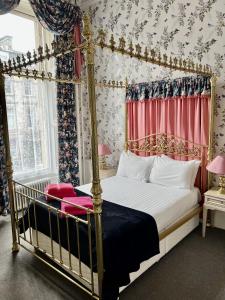 a bedroom with a canopy bed with red curtains at Eliza House in Edinburgh