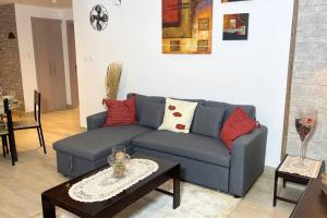 Cowboy Charm 1BR Apartment on Yas Island في أبوظبي: غرفة معيشة مع أريكة زرقاء وطاولة