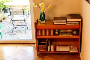 un estante de libros con libros y un jarrón con flores en Design Ferienwohnung mit Bauerngarten en Waldkirchen