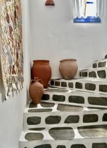 two vases are sitting on a tiled floor at Nostos Studios in Parikia