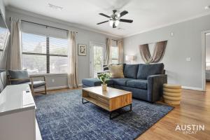奥斯汀Charming and Spacious Apt in Austin with a Pool的客厅里有一张蓝色的沙发和一张桌子