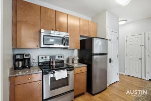 a kitchen with stainless steel appliances and wooden cabinets at Charming and Spacious Apt in Austin with a Pool in Austin