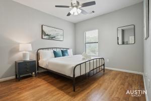 奥斯汀Charming and Spacious Apt in Austin with a Pool的带床和吊扇的卧室