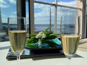 deux verres de champagne sur une table avec une assiette de fleurs dans l'établissement Appartement Corniche II - Superbe Vue Mer !!! wir sprechen flieBen deutsch, Touristentipps, we speak English, à Concarneau