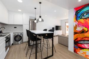 kuchnia ze stołem, krzesłami i obrazem w obiekcie ApartUP La Concha Beachfront II w mieście Oropesa del Mar