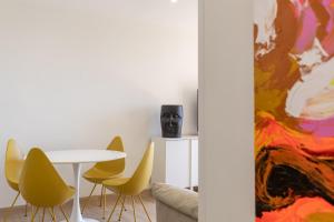 jadalnia ze stołem i żółtymi krzesłami w obiekcie ApartUP La Concha Beachfront II w mieście Oropesa del Mar