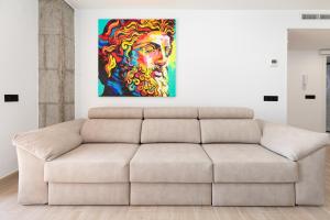 una sala de estar con sofá y una pintura en la pared en ApartUP La Concha Beachfront II, en Oropesa del Mar