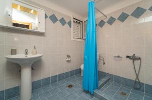 W łazience znajduje się prysznic i umywalka. w obiekcie ANEMI APARTMENTs w mieście Finikounda