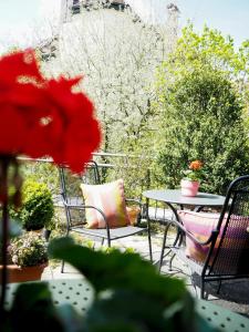 a patio with a table and chairs and flowers at Das Altschwabing - Munich Boutique Hotel in Munich