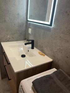 La salle de bains est pourvue d'un lavabo, d'un miroir et de toilettes. dans l'établissement Kasprzaka Beautiful City View Apartament, à Varsovie